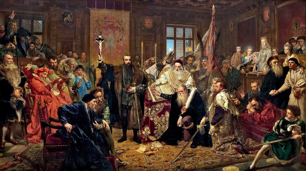 Jan Matejko's painting of the Union of Lublin: a crowded hall of nobles, bishops and envoys around a raised crucifix, one man kneeling with a sword.